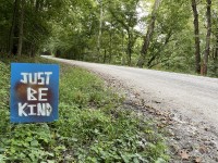 Just Be Kind sign on a rural road